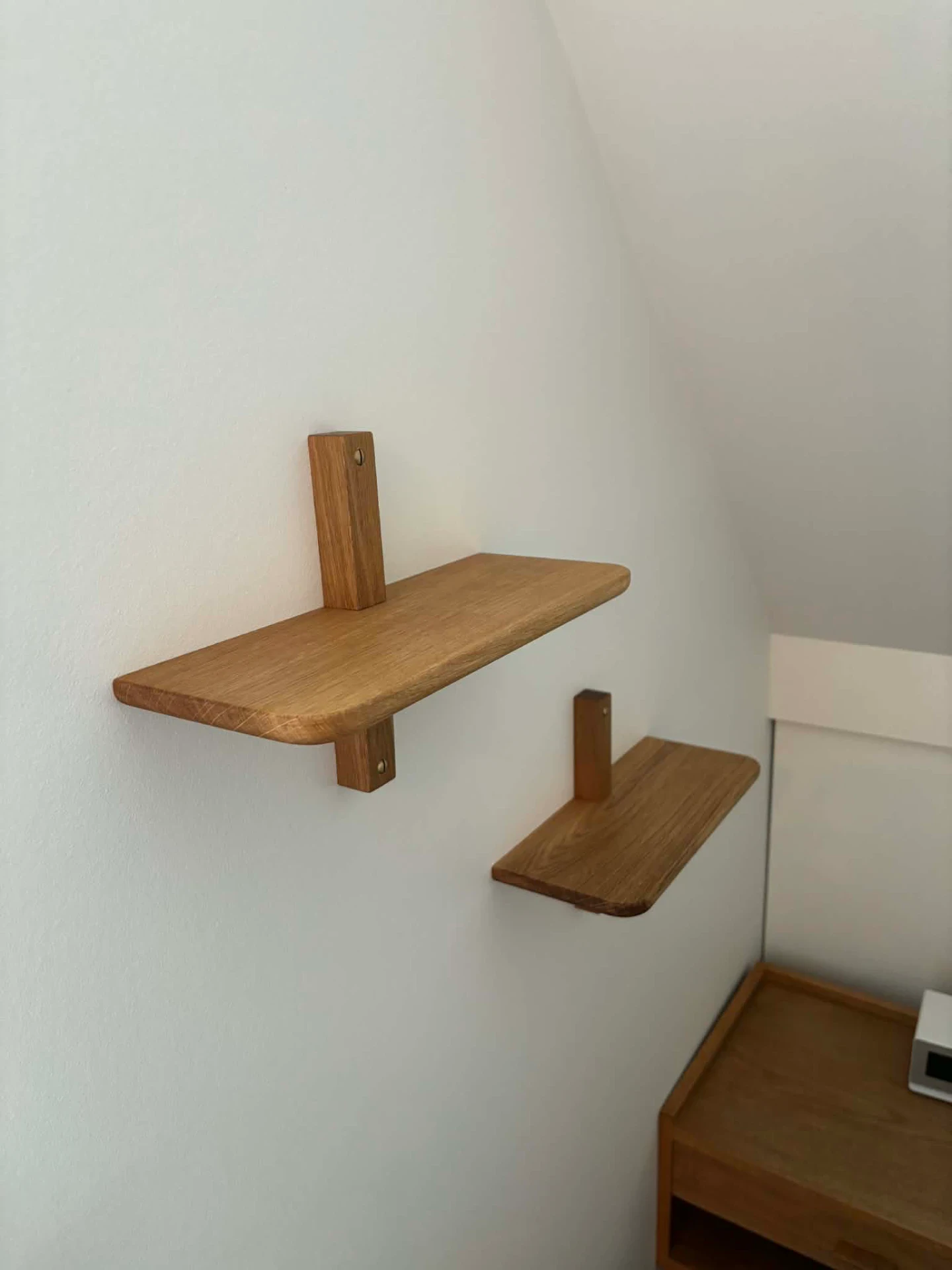 To træhylder monteret på hvid væg, perfekt til opbevaring og dekoration.
