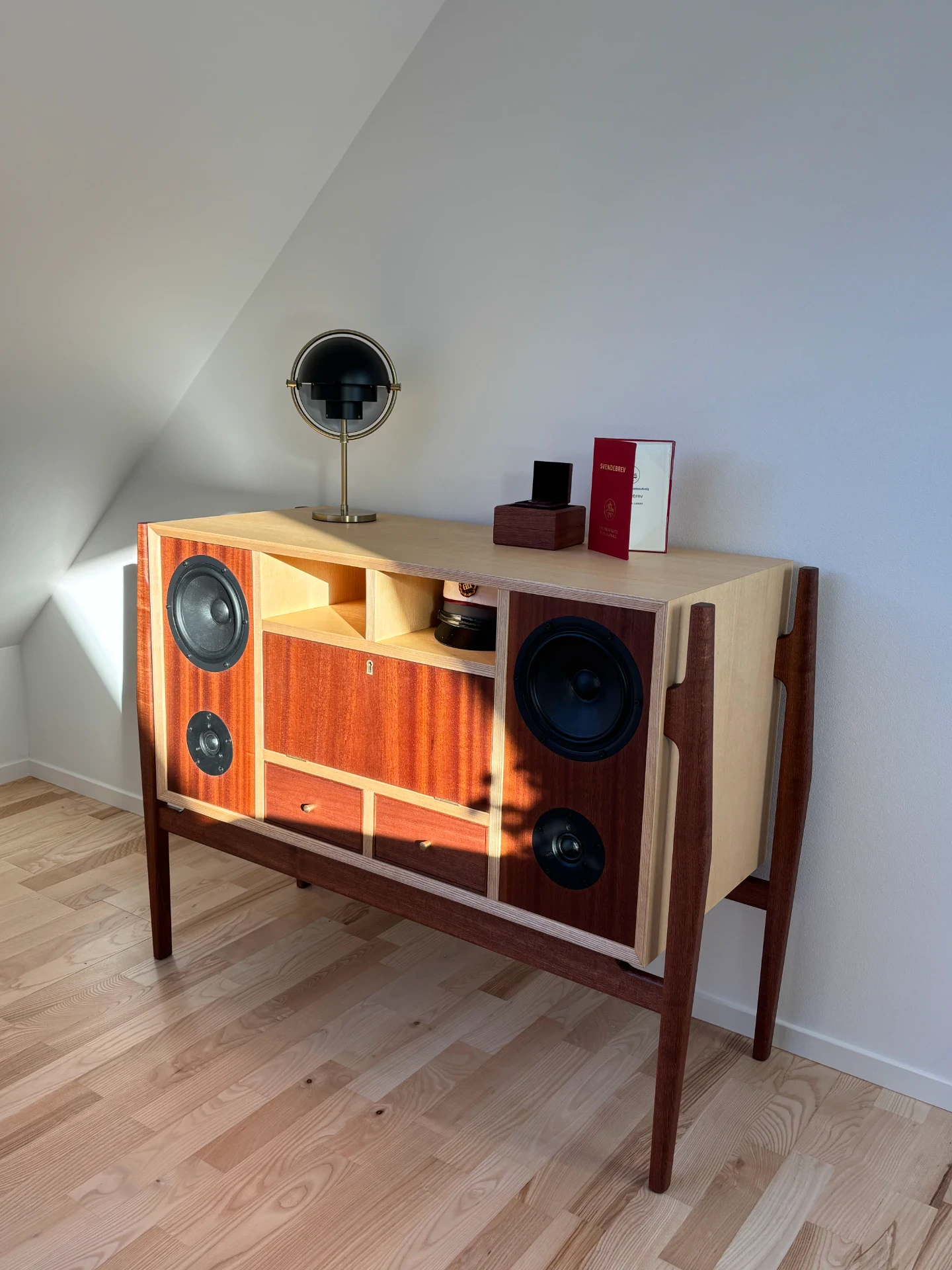Højttalerskab i træ med vintage-inspireret design og indbyggede højttalere.