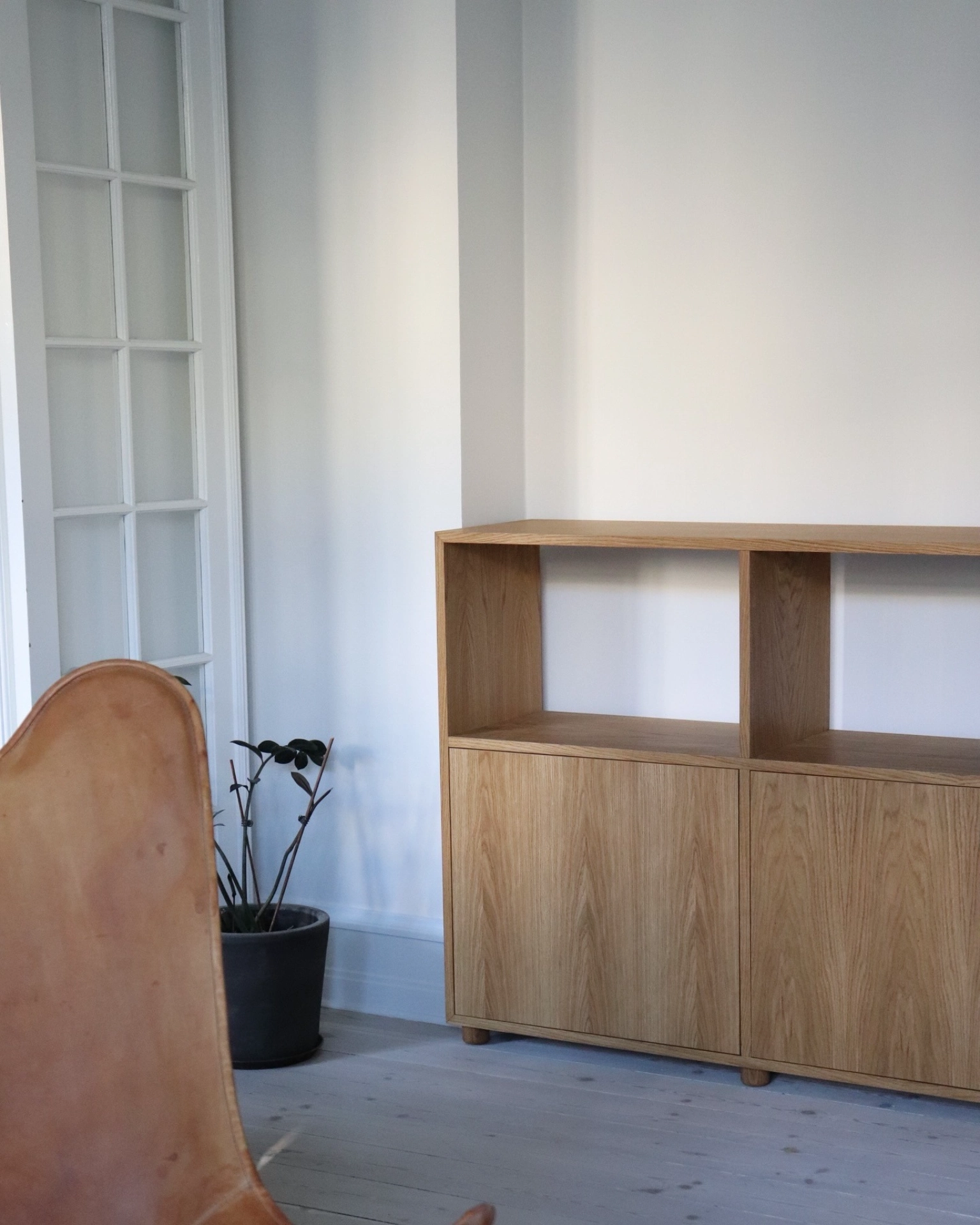Elegant træskab i minimalistisk kontorindretning.