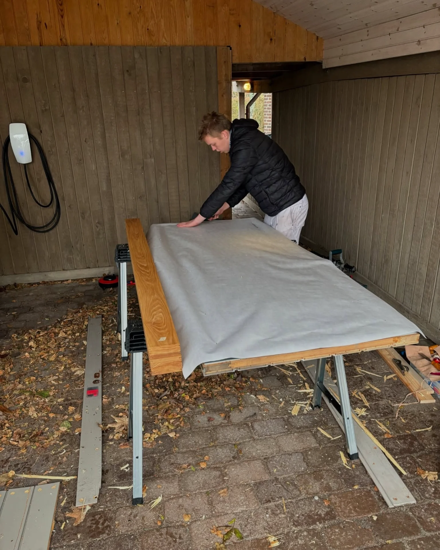 Håndværker forbereder arbejdsbord med stof til snedkerarbejde.
